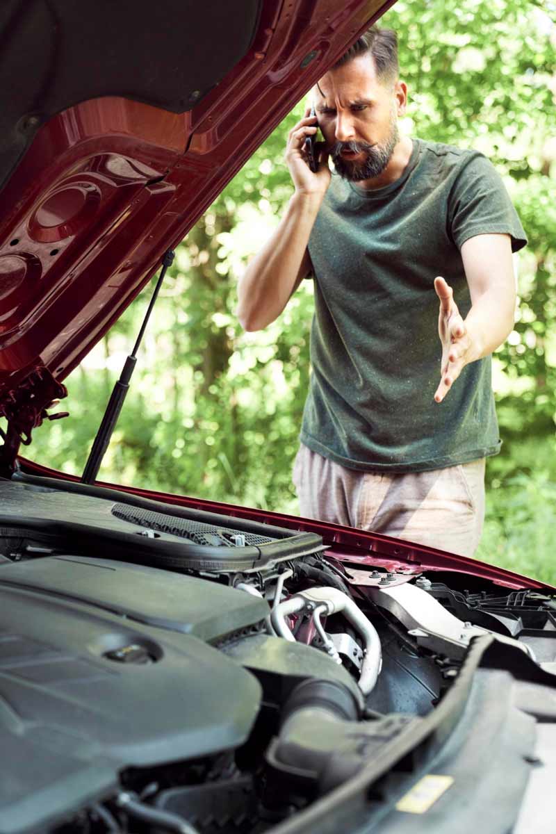 Junger Mann prüft Getriebeschaden bei Schrottauto Ankauf Nordfriesland